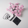 Lampe de table LED en rose avec des roses noires et un fil attaché.