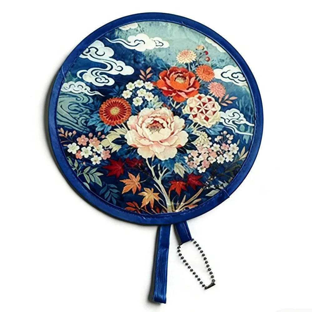 A round fabric fan featuring a detailed floral design in shades of blue, orange, and pink.