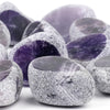 A collection of tumbled natural crystals including clear quartz, rose quartz, and amethyst stones.