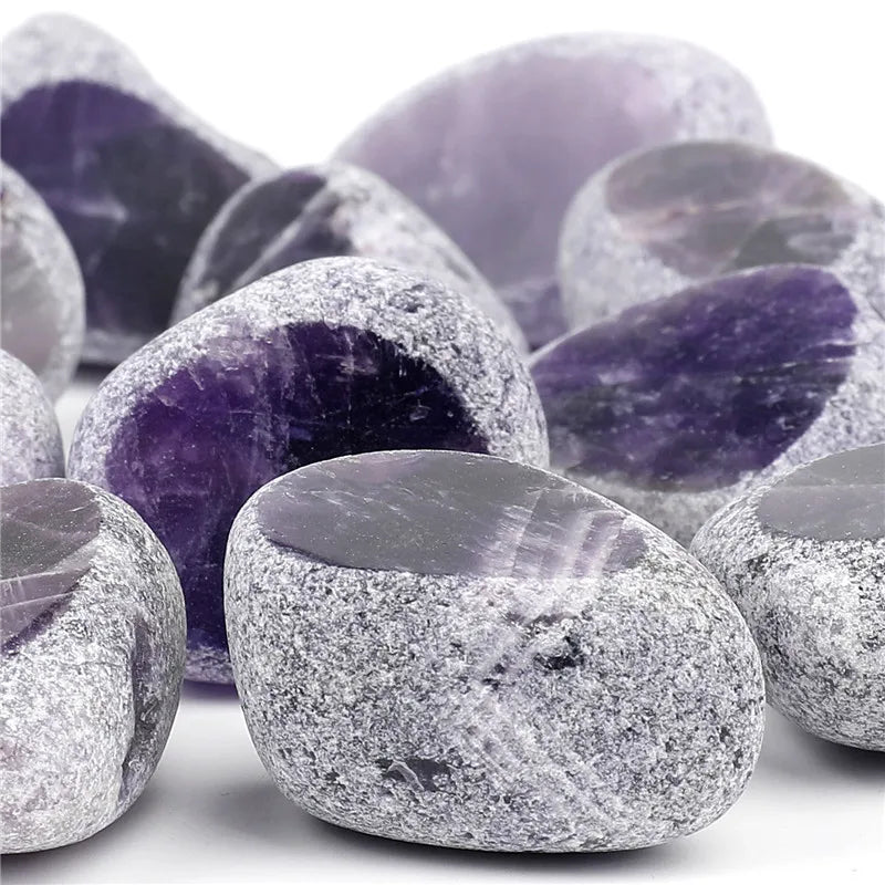 A collection of tumbled natural crystals including clear quartz, rose quartz, and amethyst stones.