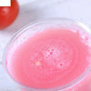 A close-up of a pink, bubbly liquid in a clear plastic cup with a dome lid.