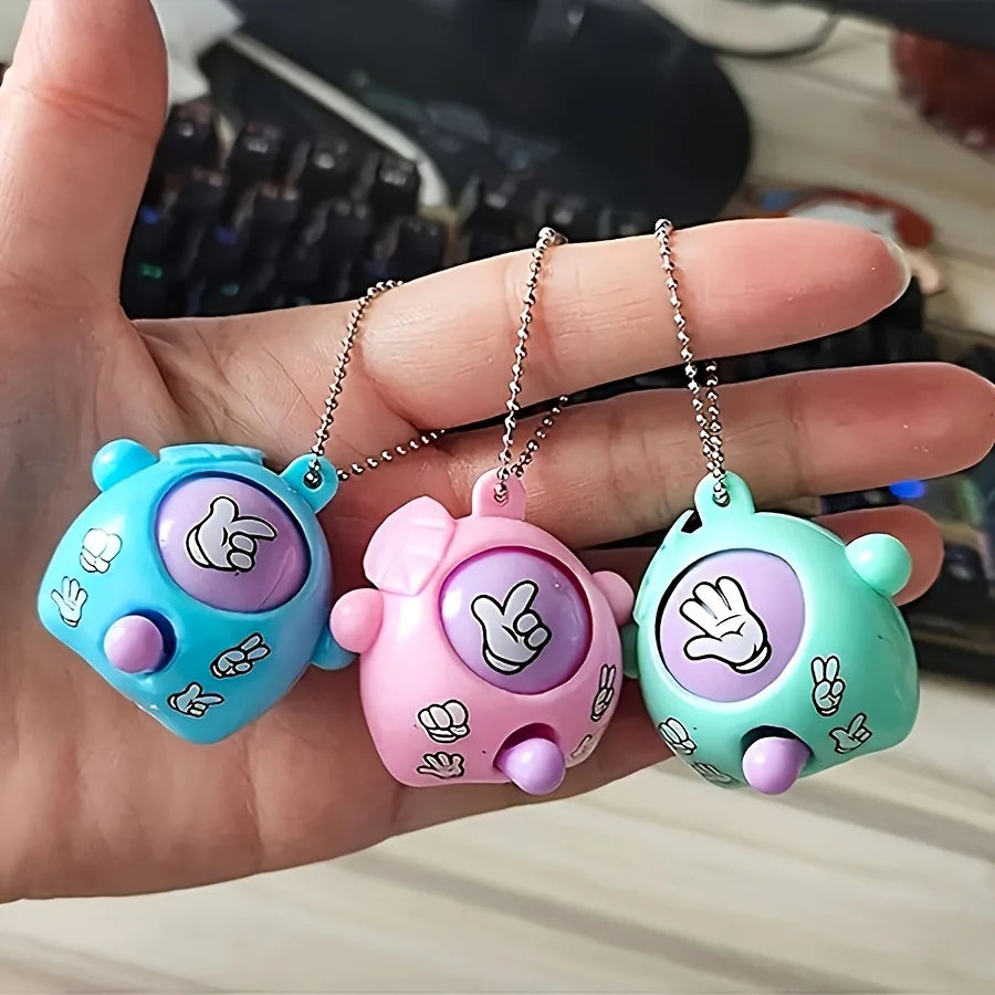 Three pastel colored mini rock paper scissors keychains with a cute animal face design