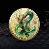 A gold-colored collectible coin featuring a detailed green dragon with a Tai Chi motif against a dark background.