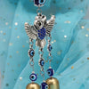 Carillon à aile d'argent avec accents bleu et or, suspendu sur un fond de tissu bleu clair