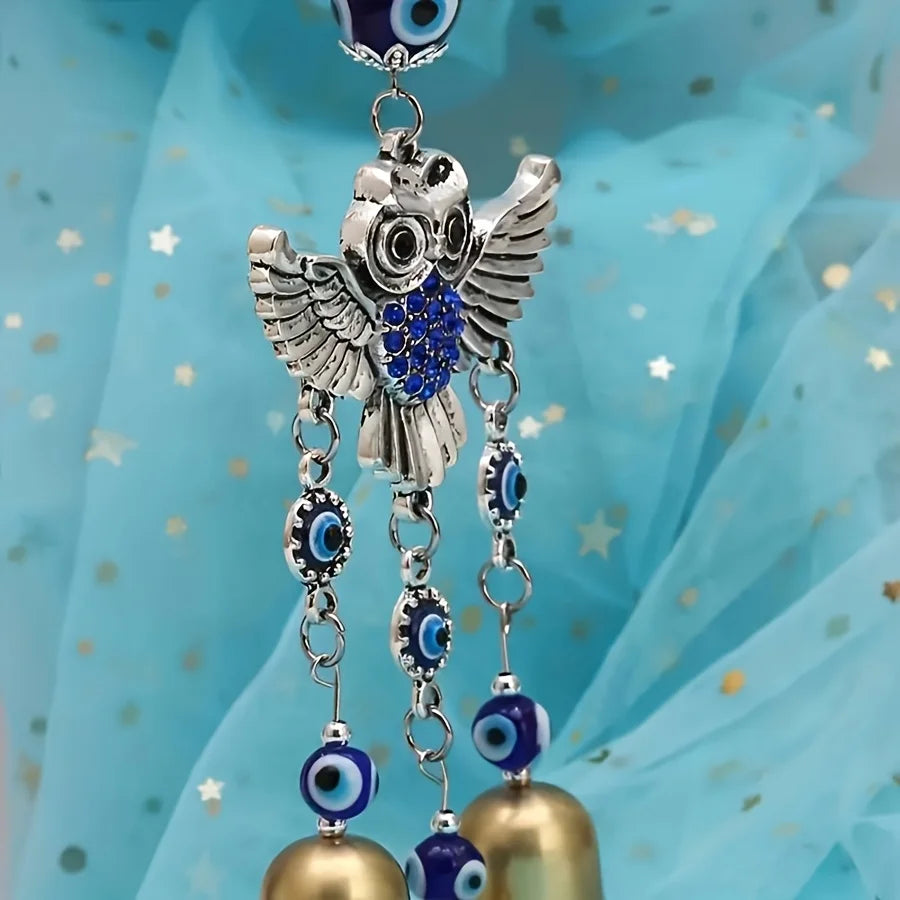 Carillon à aile d'argent avec accents bleu et or, suspendu sur un fond de tissu bleu clair