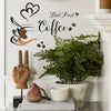 A wall sticker featuring a hand blowing steam towards coffee beans and the text But First Coffee