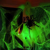 A glowing green spider web decoration with fake spiders hanging from a ceiling.