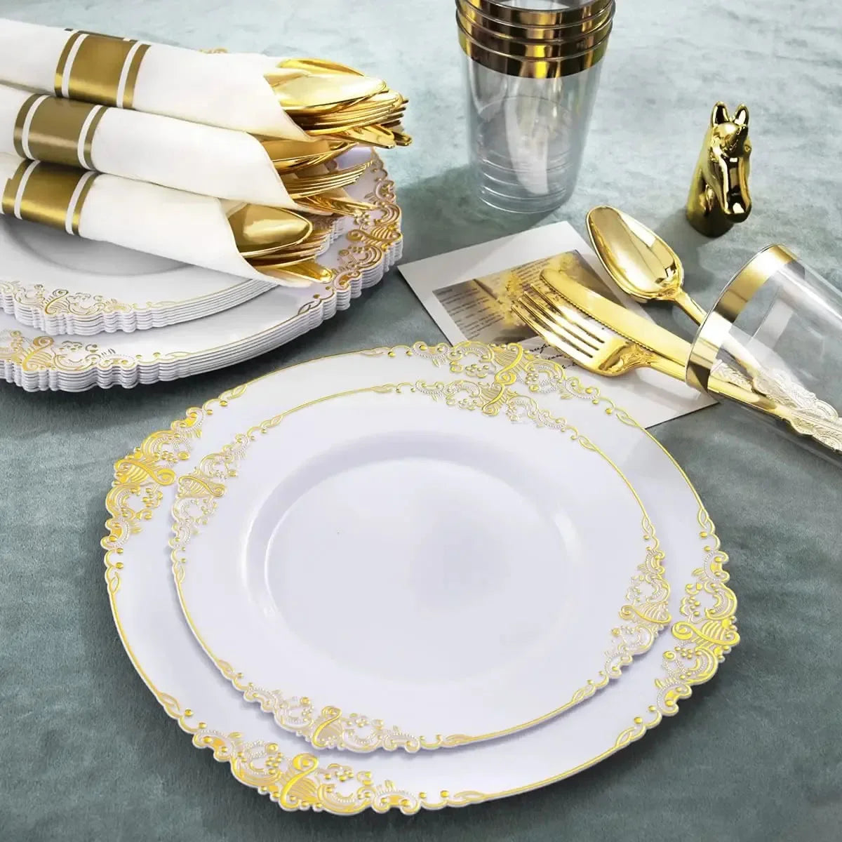 Elegant white and gold disposable dinnerware set including plates and cutlery