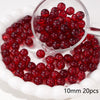 A clear glass bowl filled with 20 red round beads for jewelry making