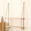 Rustic wooden hanging shelves with rope mounted on a white wall.