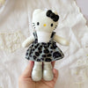 A handmade plush doll resembling a cat with black and white leopard print clothing.