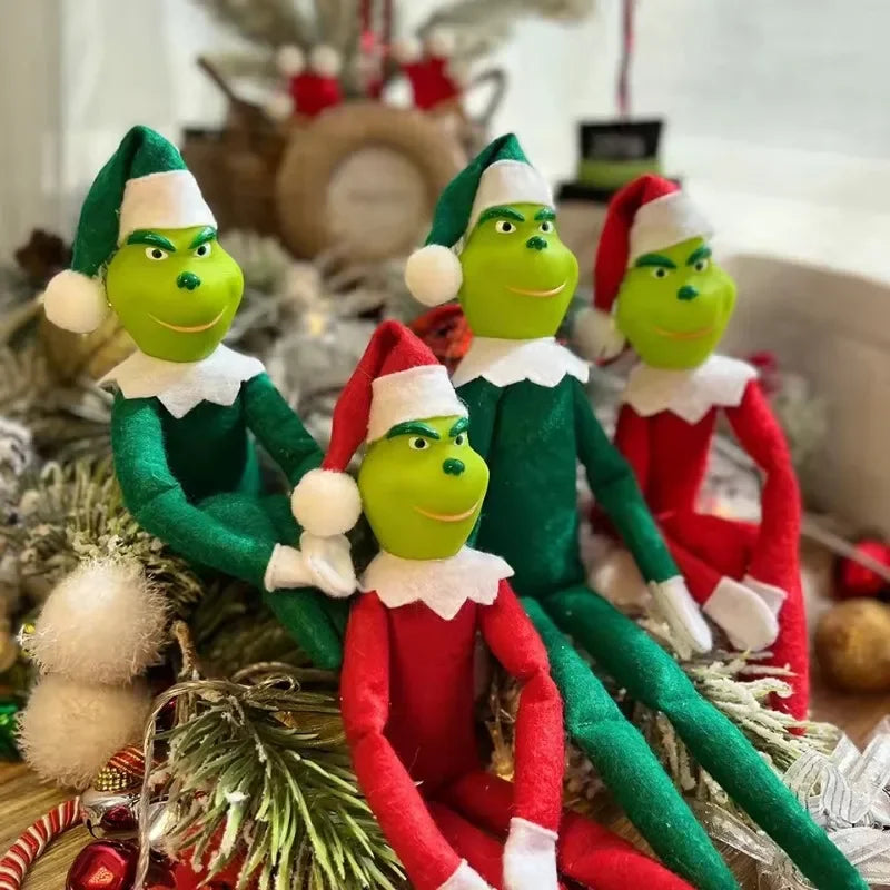 Un sapin de Noël d'elfe vert en peluche portant un bonnet de Père Noël, assis sur une branche de conifère festive.