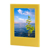 A yellow magnetic double-sided frame displaying a scenic view of the ocean and a green tree.