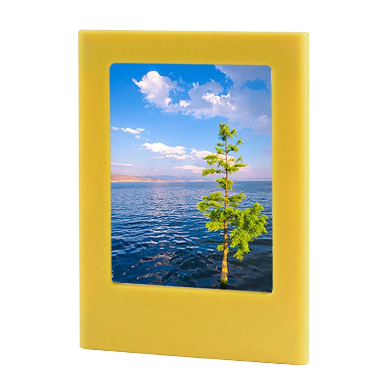 A yellow magnetic double-sided frame displaying a scenic view of the ocean and a green tree.