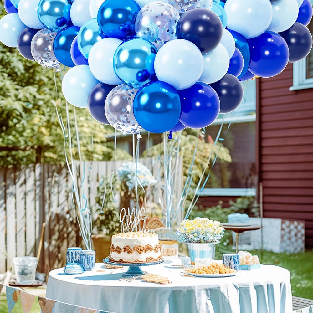 Un amas de ballons roses métalliques et or rose est exposé sur une table avec une nappe bleu clair.