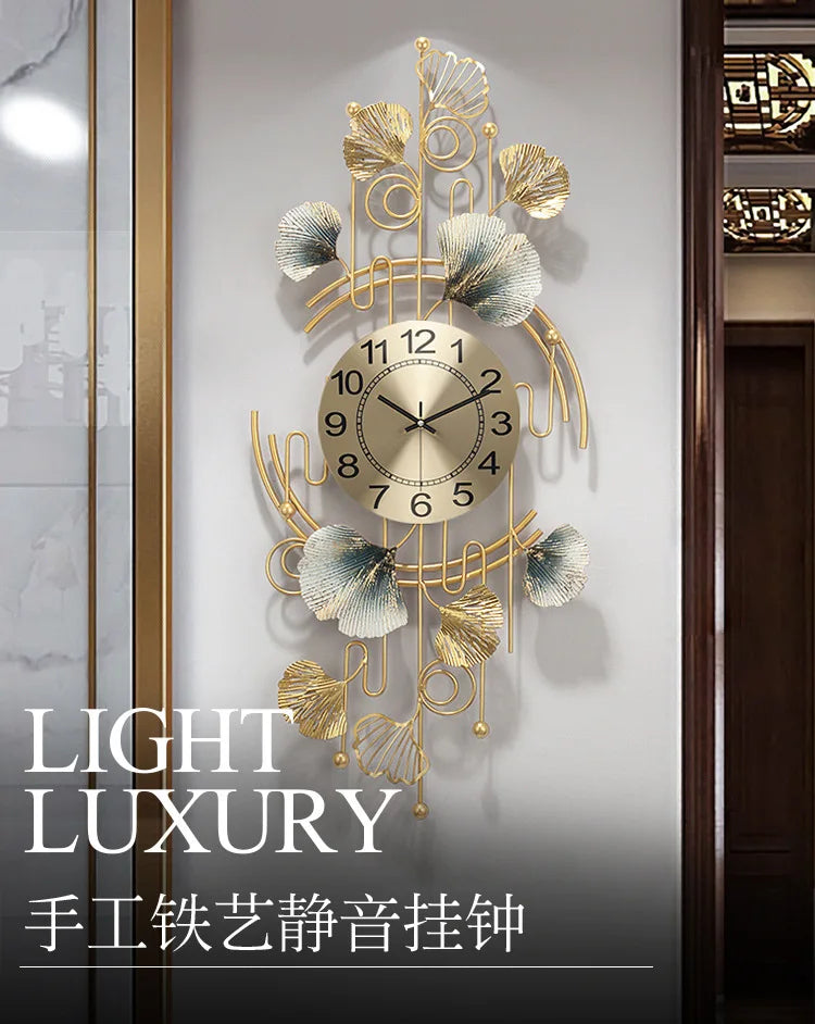 A gold-toned metal wall clock featuring decorative ginkgo leaves and a round face, mounted on a light gray wall.