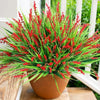 A vibrant arrangement of artificial red lavender sprigs in a terracotta pot.