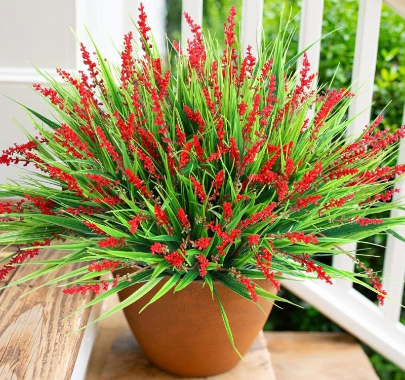 A vibrant arrangement of artificial red lavender sprigs in a terracotta pot.