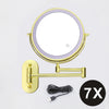A round, illuminated magnifying makeup mirror with a gold frame and USB charging cable.