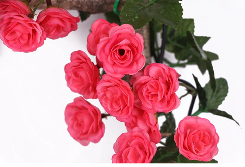 A cluster of vibrant pink silk roses on a green vine used for wedding and home decor.