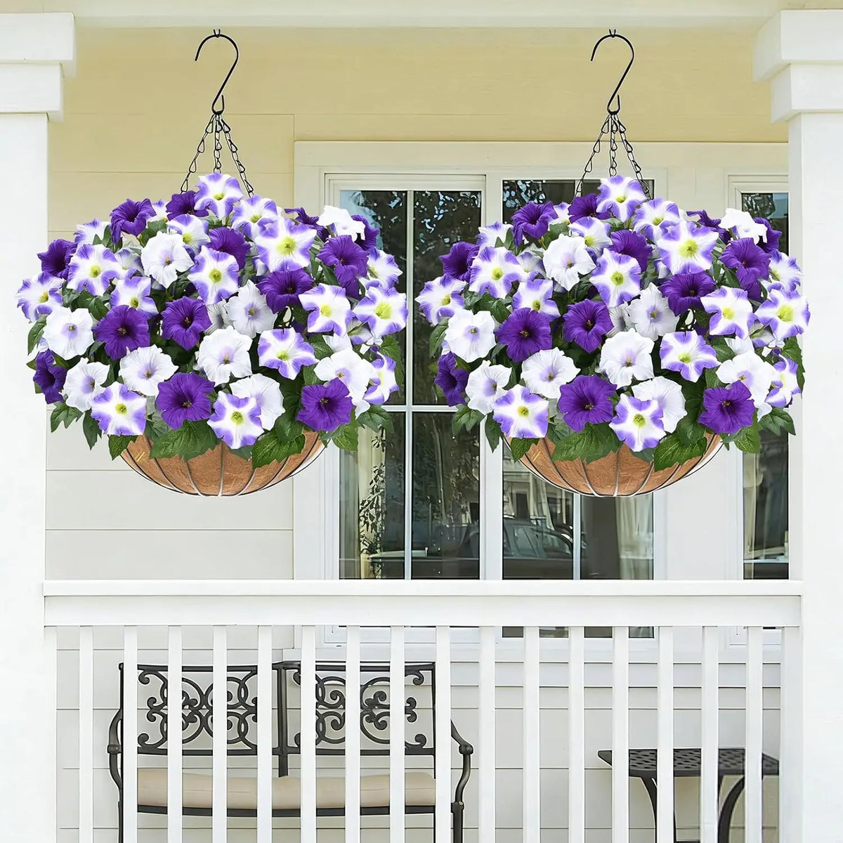Two hanging baskets filled with purple and white artificial petunia flowers and vines