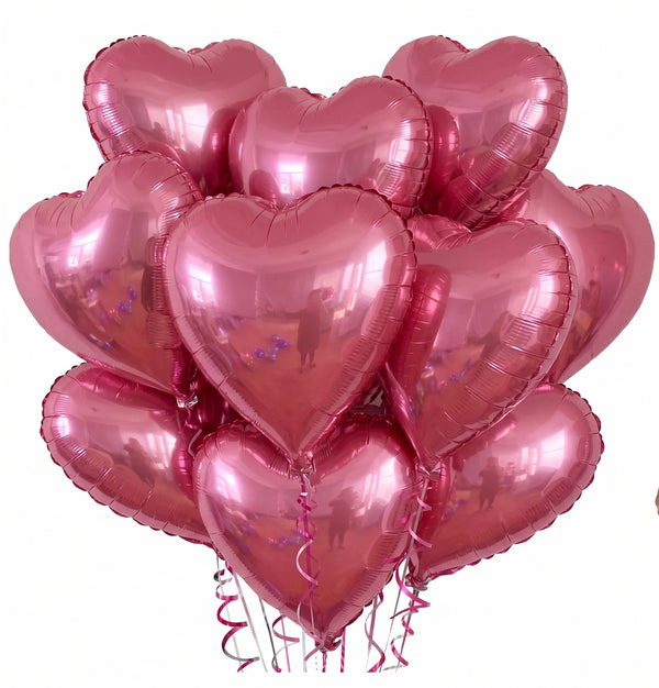 A bunch of pink heart-shaped foil balloons tied together for a party or celebration.