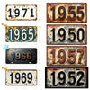 A collection of vintage aluminum license plates showing various years including 1971, 1955, 1965, 1950, 1966, 1957, 1969, and