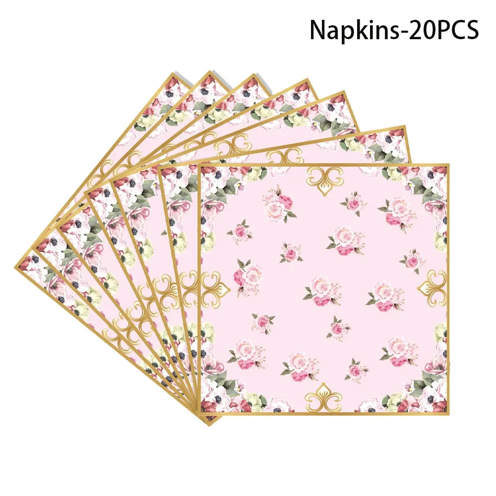 A stack of twenty pink and green floral patterned napkins with gold trim.