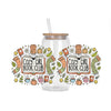 A glass jar with a cork stopper and a straw, surrounded by decorative stickers featuring books and natural elements.