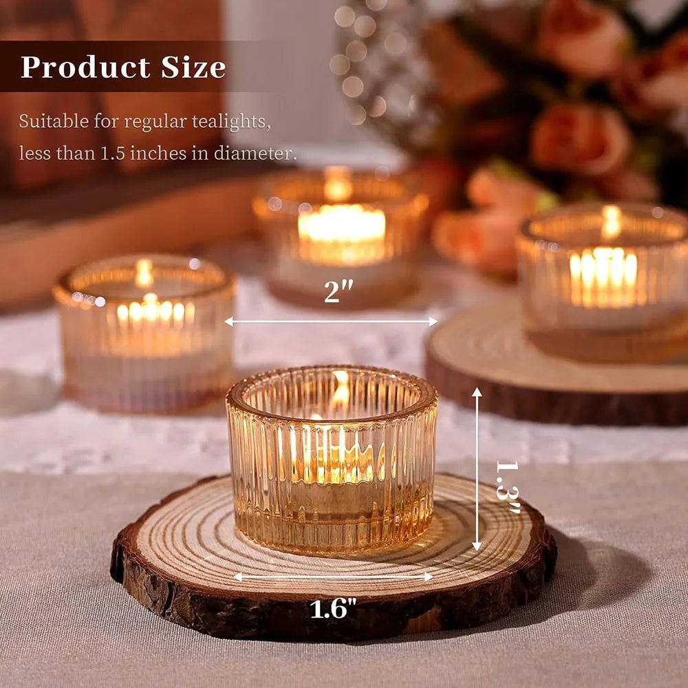Gold glass tealight candle holders resting on a wooden slice with a lit candle.