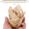 A hand holds a sheet of tulip flower shaped newspaper style cupcake liners.