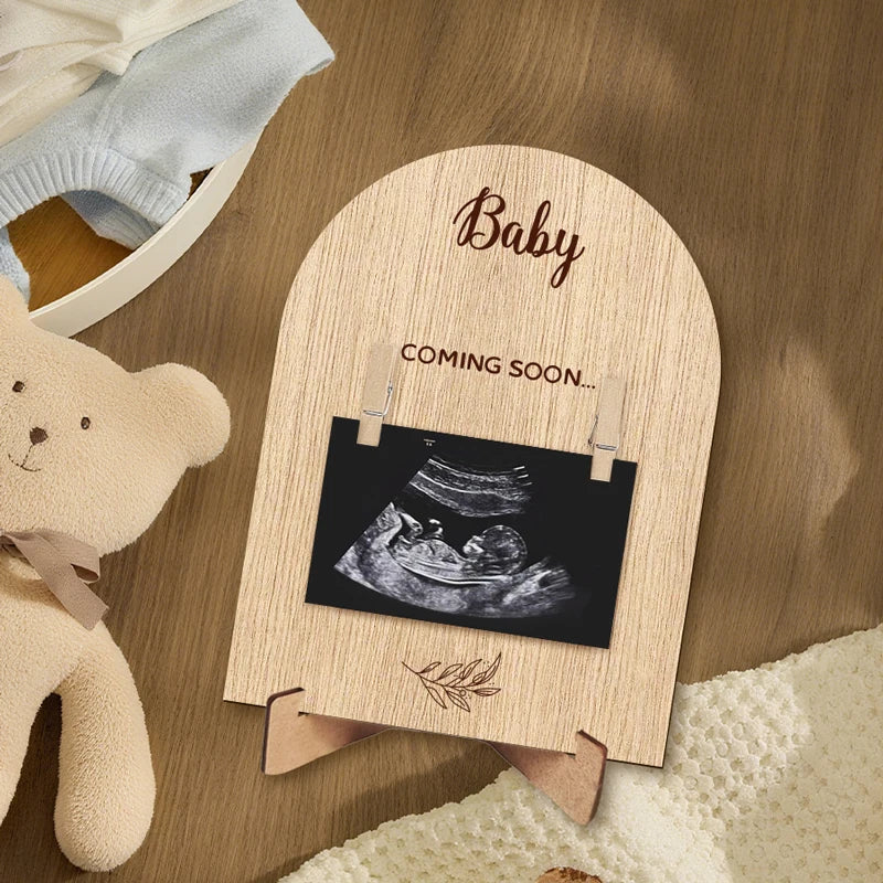 A wooden pregnancy announcement photo frame with a baby ultrasound image and the word Baby