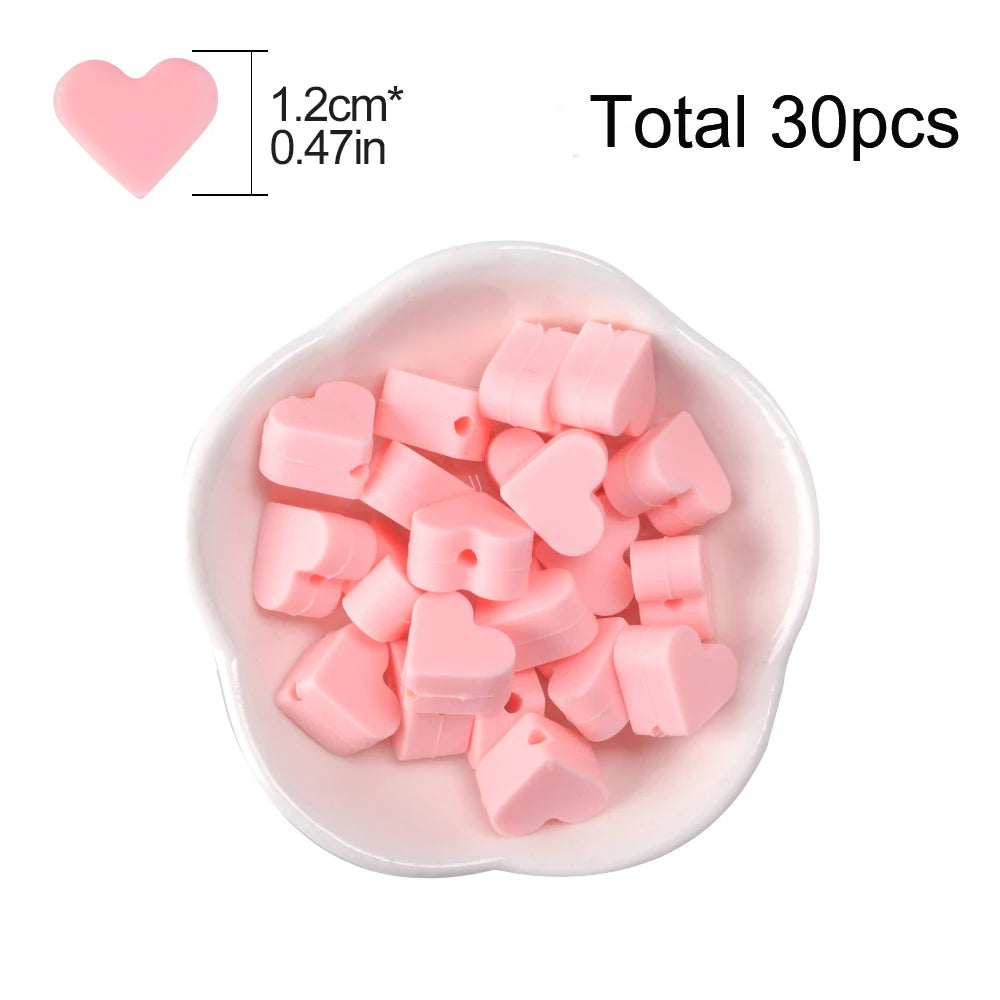 A pile of pink silicone heart beads is shown in a white dish, with a heart shape indicating the bead size.