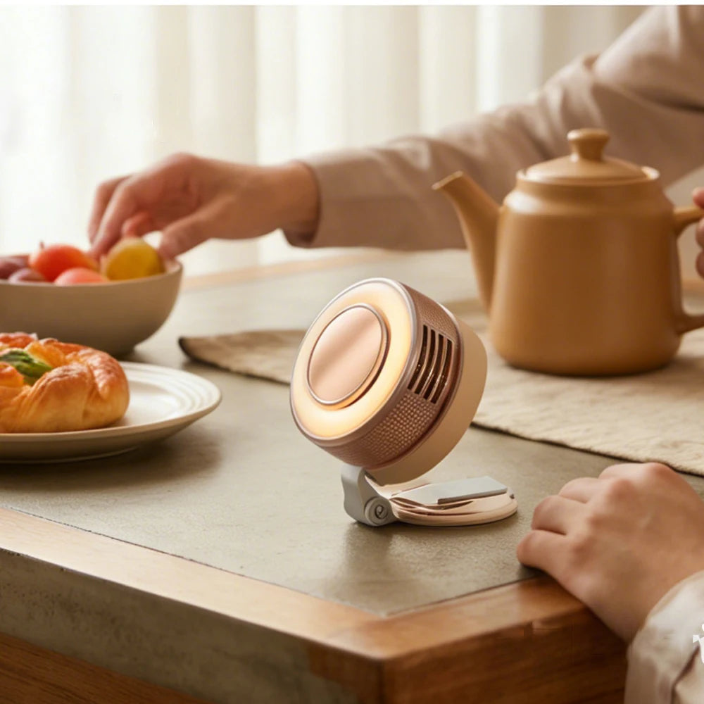A hand is operating a magnetic bladeless handheld fan on a wooden surface near a teapot and food.