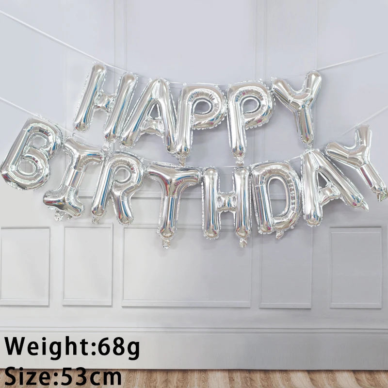 A silver foil letter birthday balloon set spelling out HAPPY BIRTHDAY hanging on a white wall.