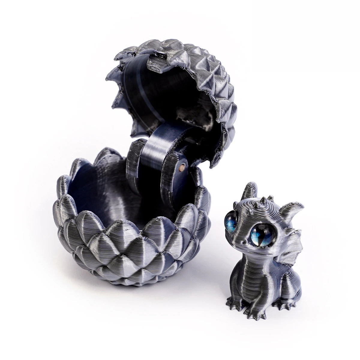 A dark gray dragon egg is cracked open, revealing a small, detailed miniature dragon toy inside.
