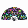 A black folding hand fan decorated with colorful fluorescent and UV glow mushrooms and psychedelic patterns.