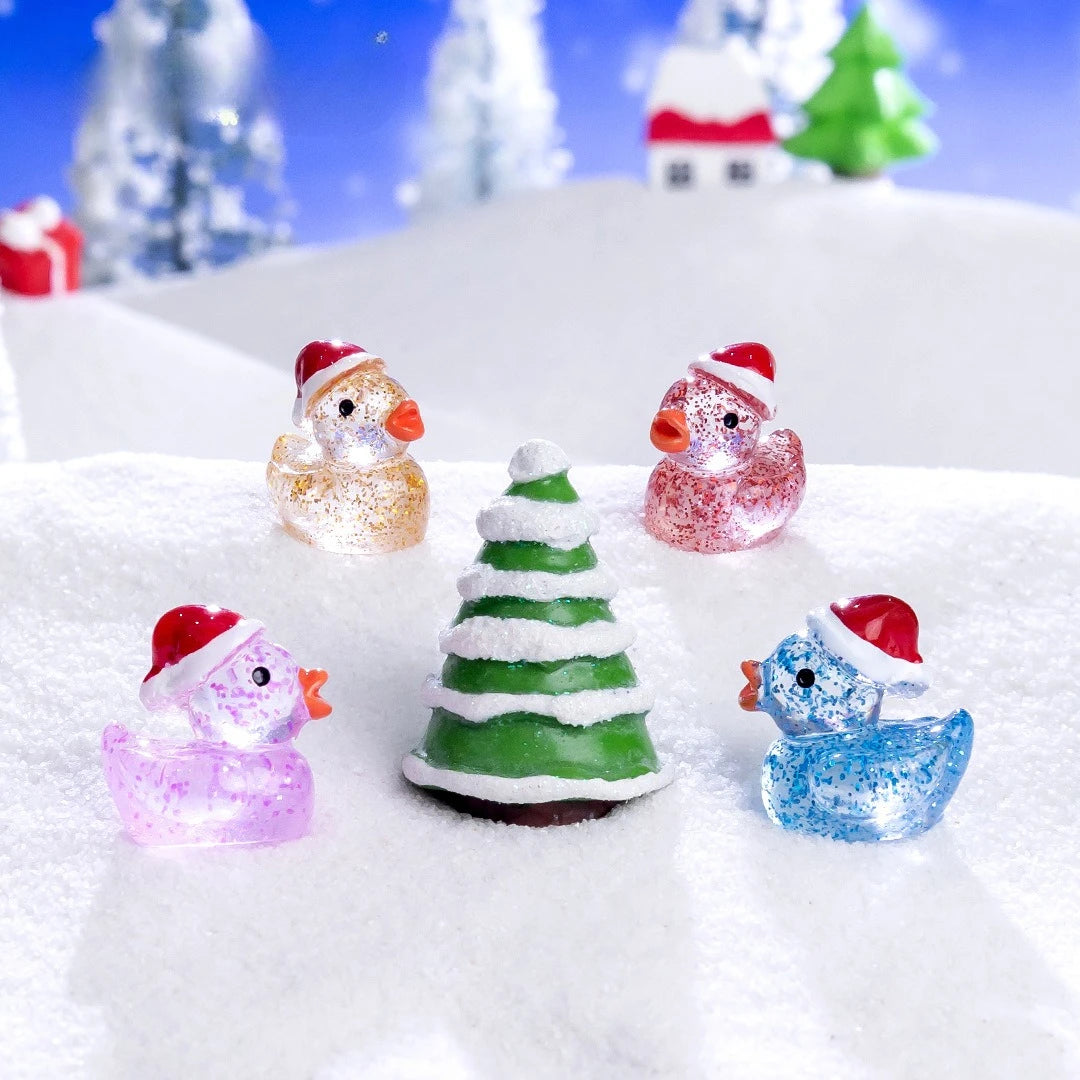 A collection of glow-in-the-dark Christmas duck figurines with Santa hats resting on a snowy surface.