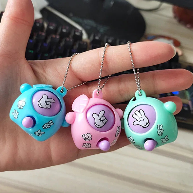 Three cute silicone guessing game eggs in blue, pink, and green are held in a hand.