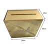 A rectangular gold-colored acrylic gift box with a slanted lid and cursive writing on the front.