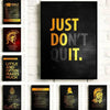 A gallery wall featuring four motivational quotes on black canvas art with gold lettering.