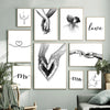 A gallery wall featuring black and white line art prints of hands, hearts, and text like love and Mr Mrs