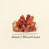A cluster of reddish-orange natural crystal stones used as a Reiki amulet or decorative figurine.