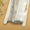 Silver metallic tinsel foil fringe curtain backdrop for parties displayed on a light brown surface.