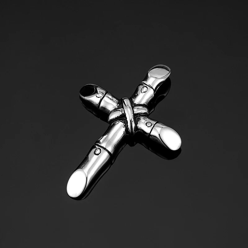 A silver stainless steel cross necklace pendant with a textured finish against a dark background.