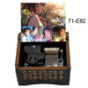 Adorno de caja musical de madera con personajes de anime, mostrado en una caja de madera oscura.