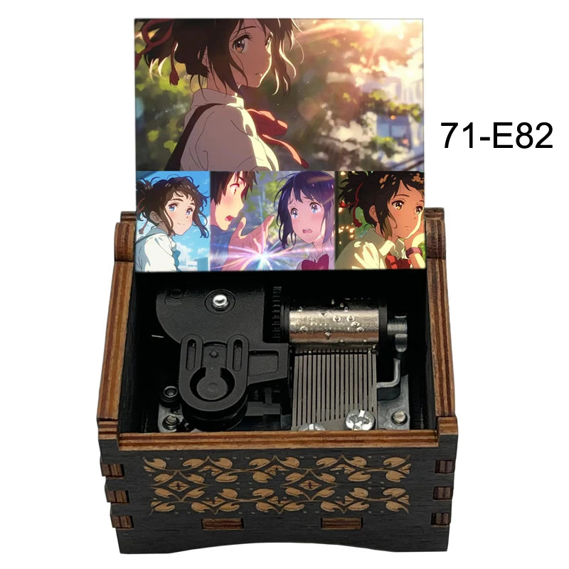 Adorno de caja musical de madera con personajes de anime, mostrado en una caja de madera oscura.