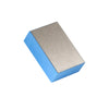 A rectangular polishing pad with a blue base and a gold textured top.