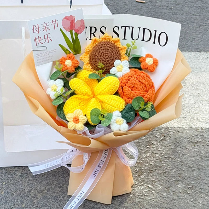 A bouquet of handmade crochet flowers in yellow, orange, and white arranged in a paper wrapping.