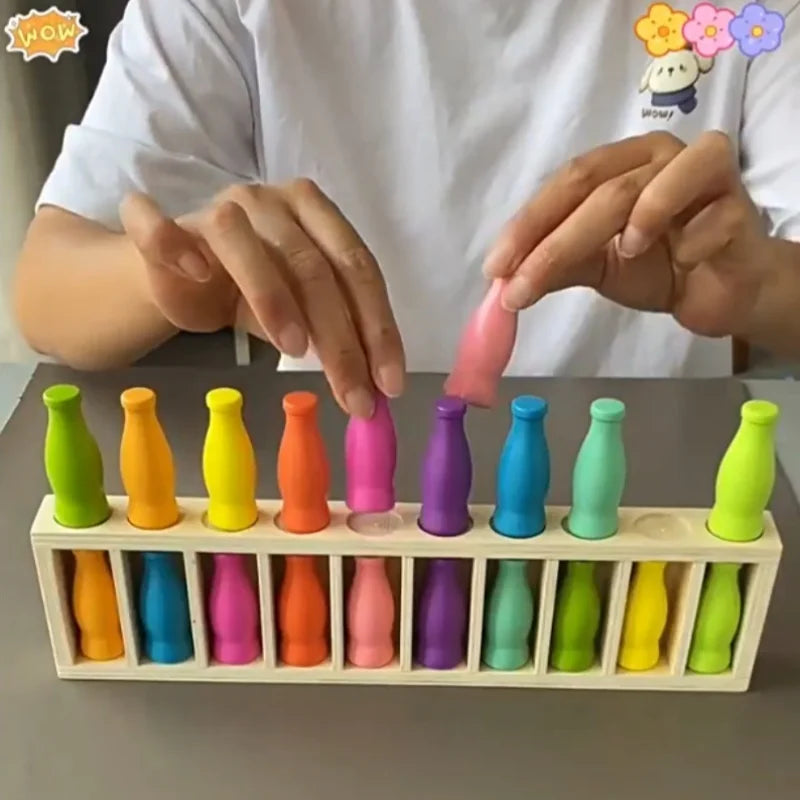 A person is demonstrating a colorful bottle matching game set with various colored plastic bottles.